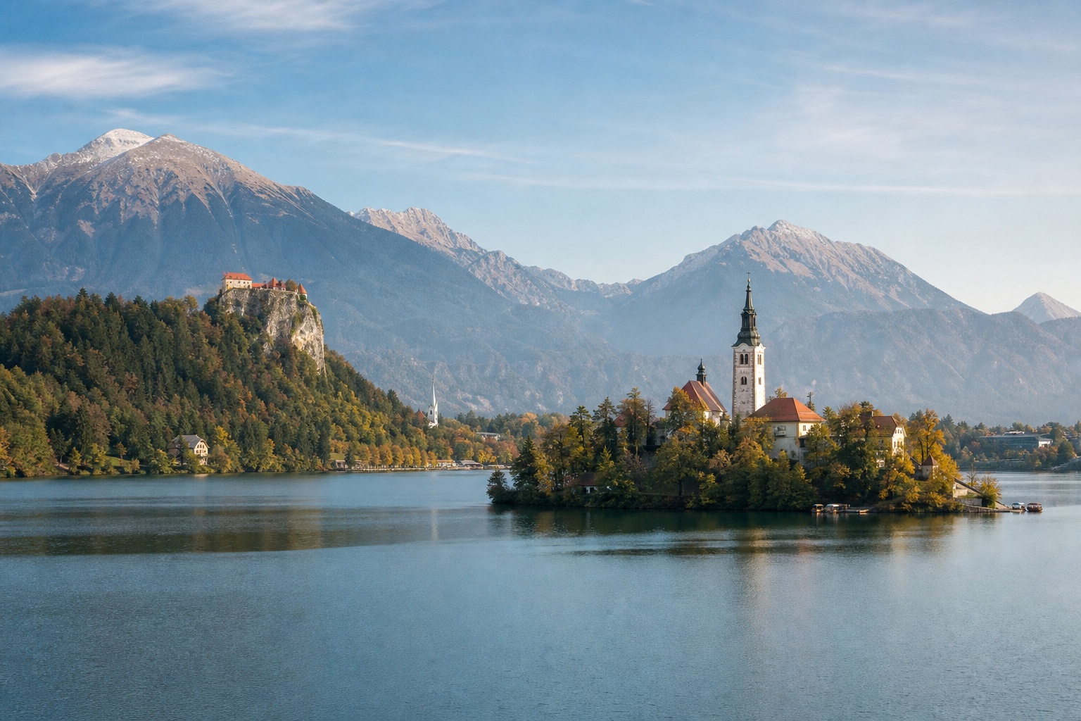 Lake Bled, island church, cliff-top castle, and Julian Alps in clear morning light