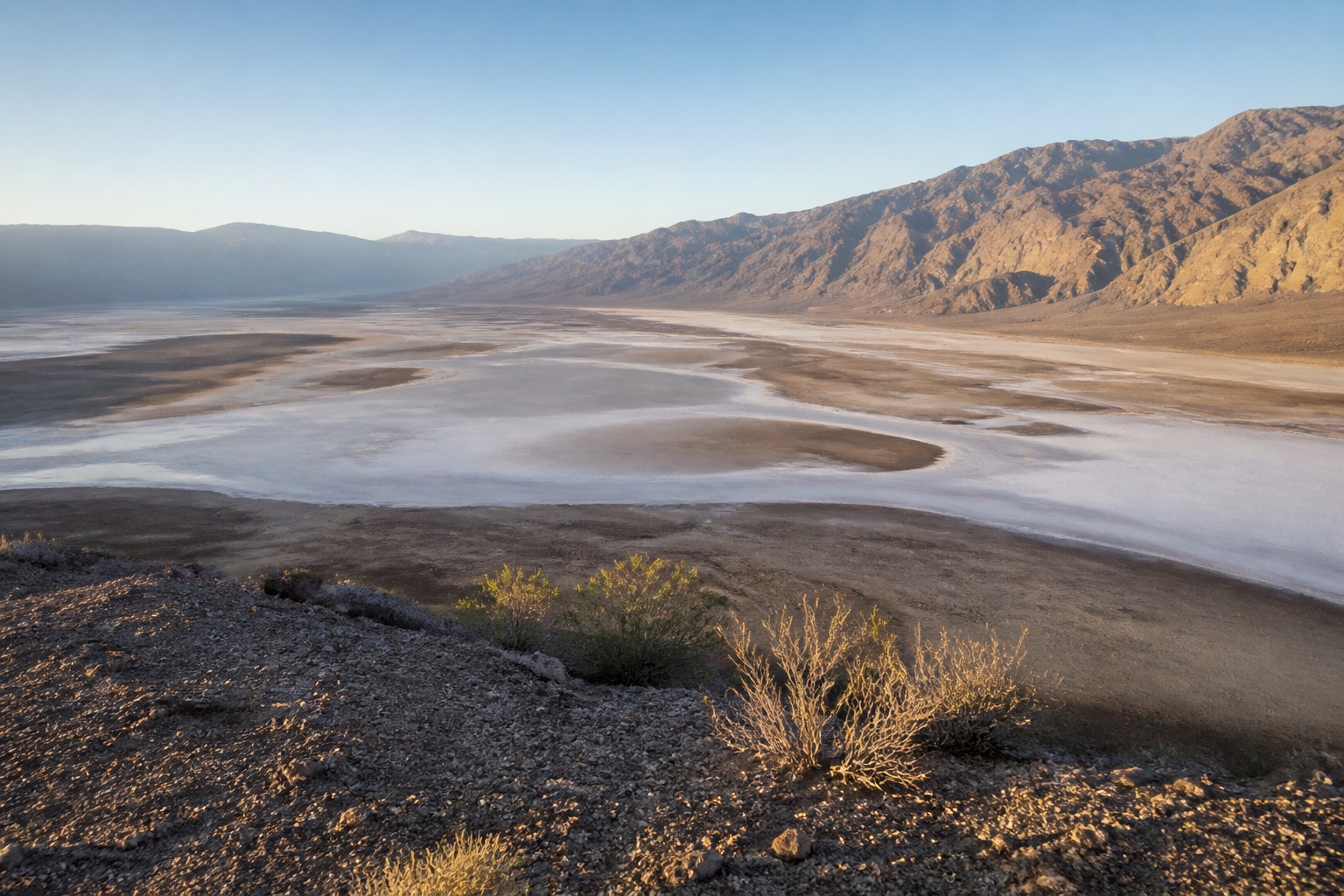 Death Valley salt flats and mountain ranges at cool first light with no people nearby