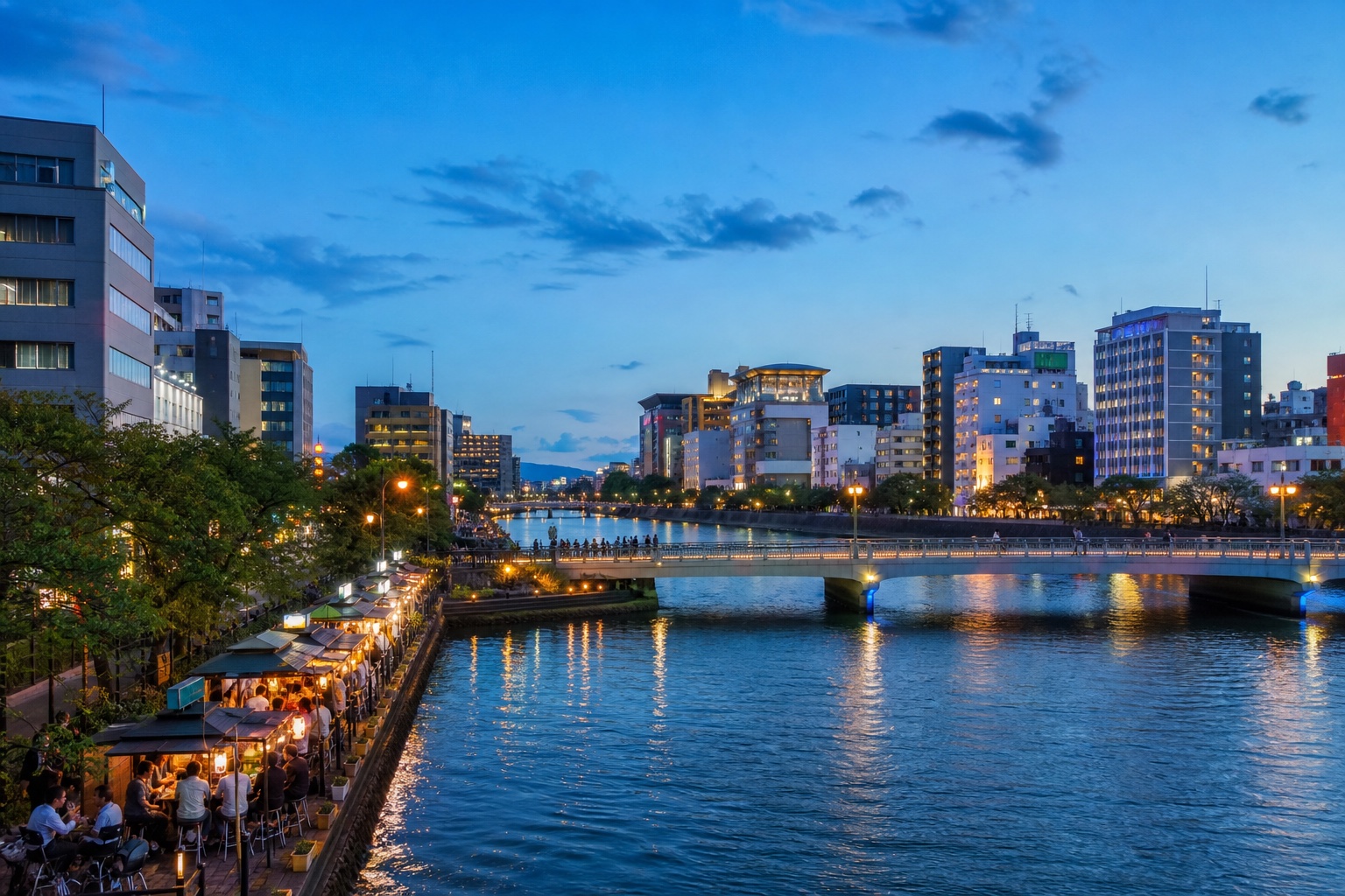 Yatai food stalls beside the Naka River and central Fukuoka at blue hour