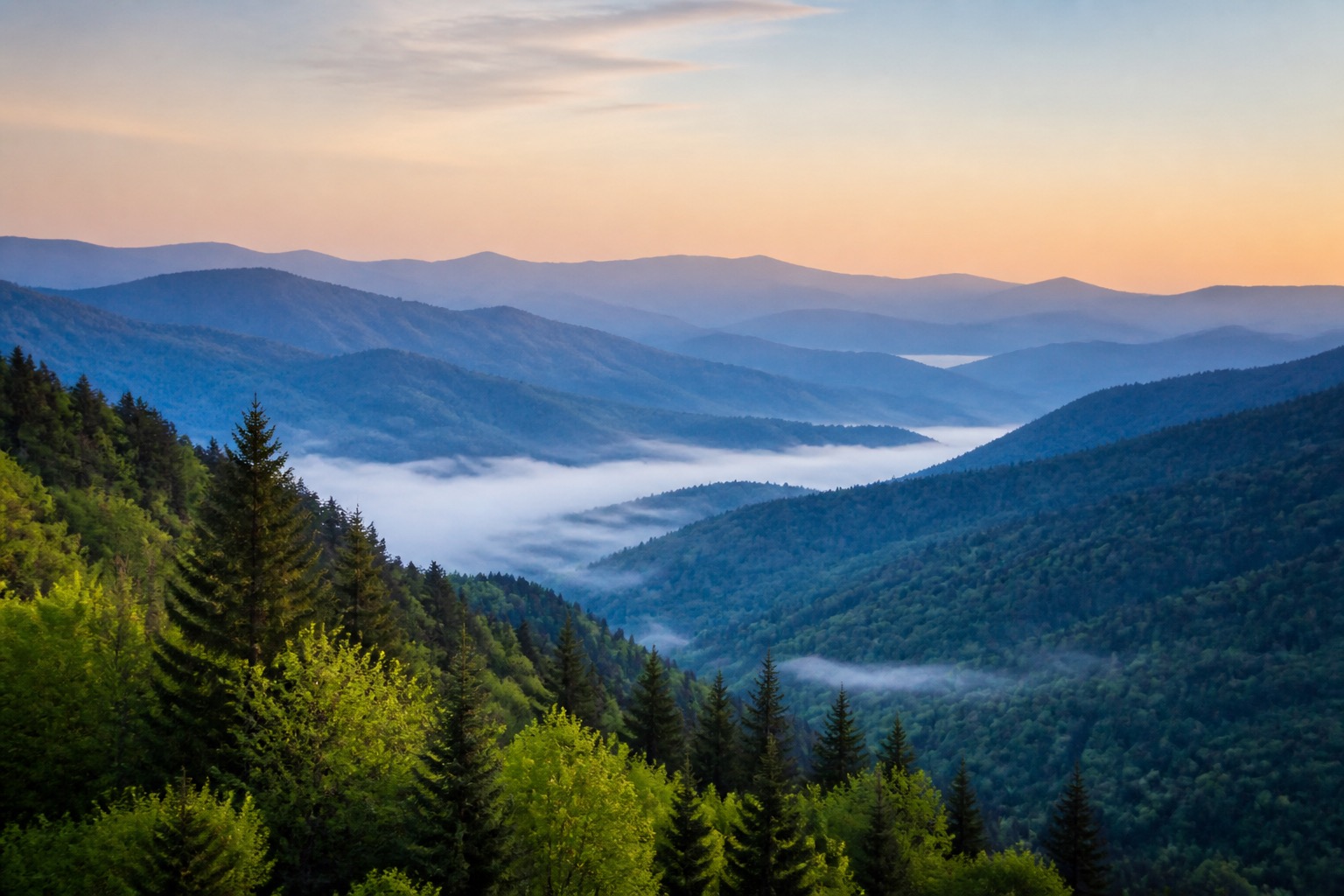 Great Smoky Mountains layered blue ridges and a misty forest valley at sunrise