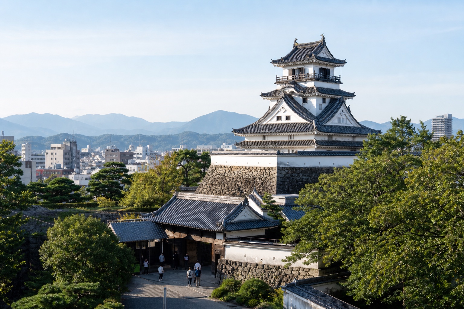 Kochi Castle's original white keep above stone walls and green grounds in clear Shikoku light