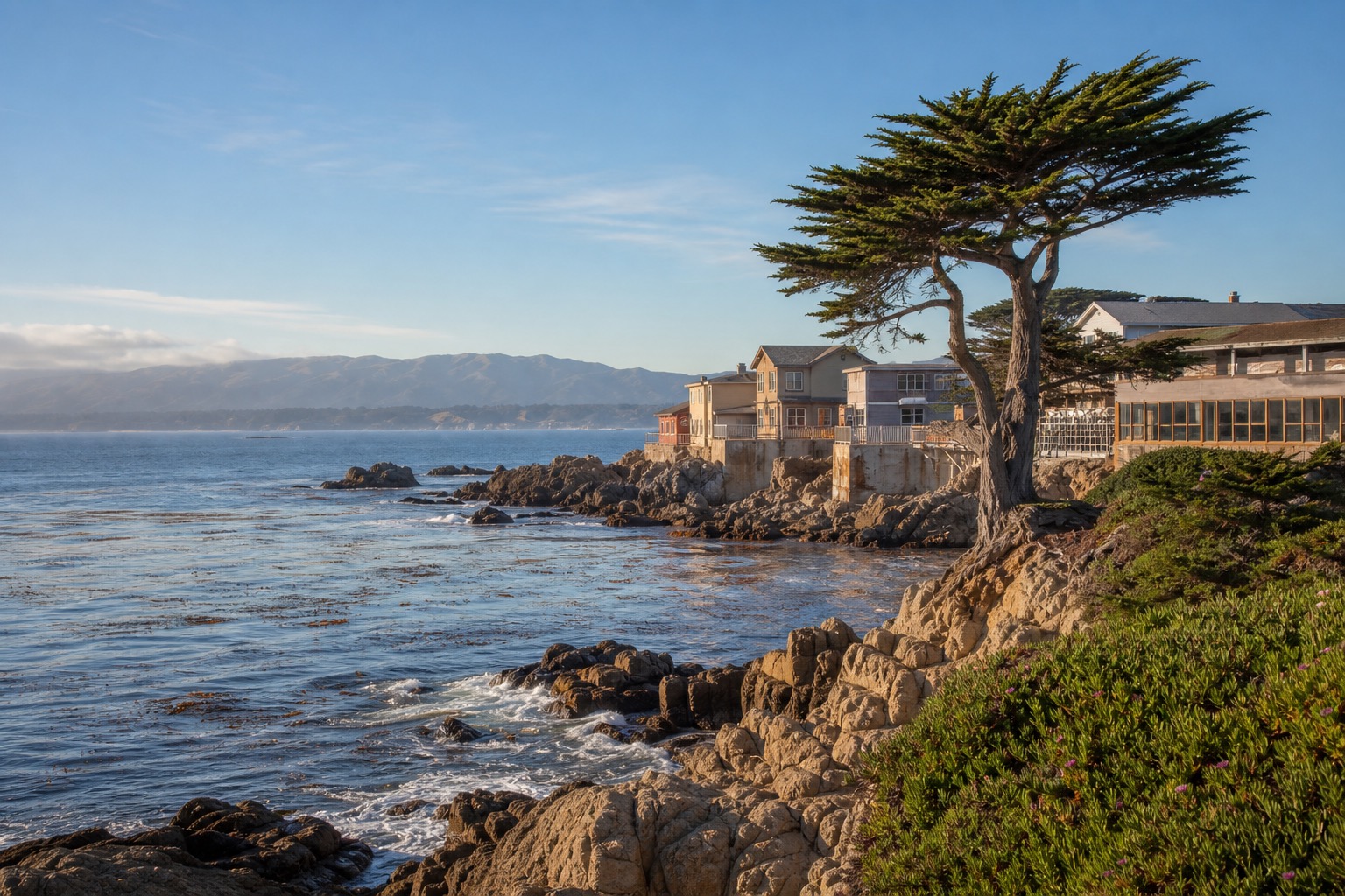 Monterey Bay waterfront with rocky coast, cypress trees and historic Cannery Row buildings