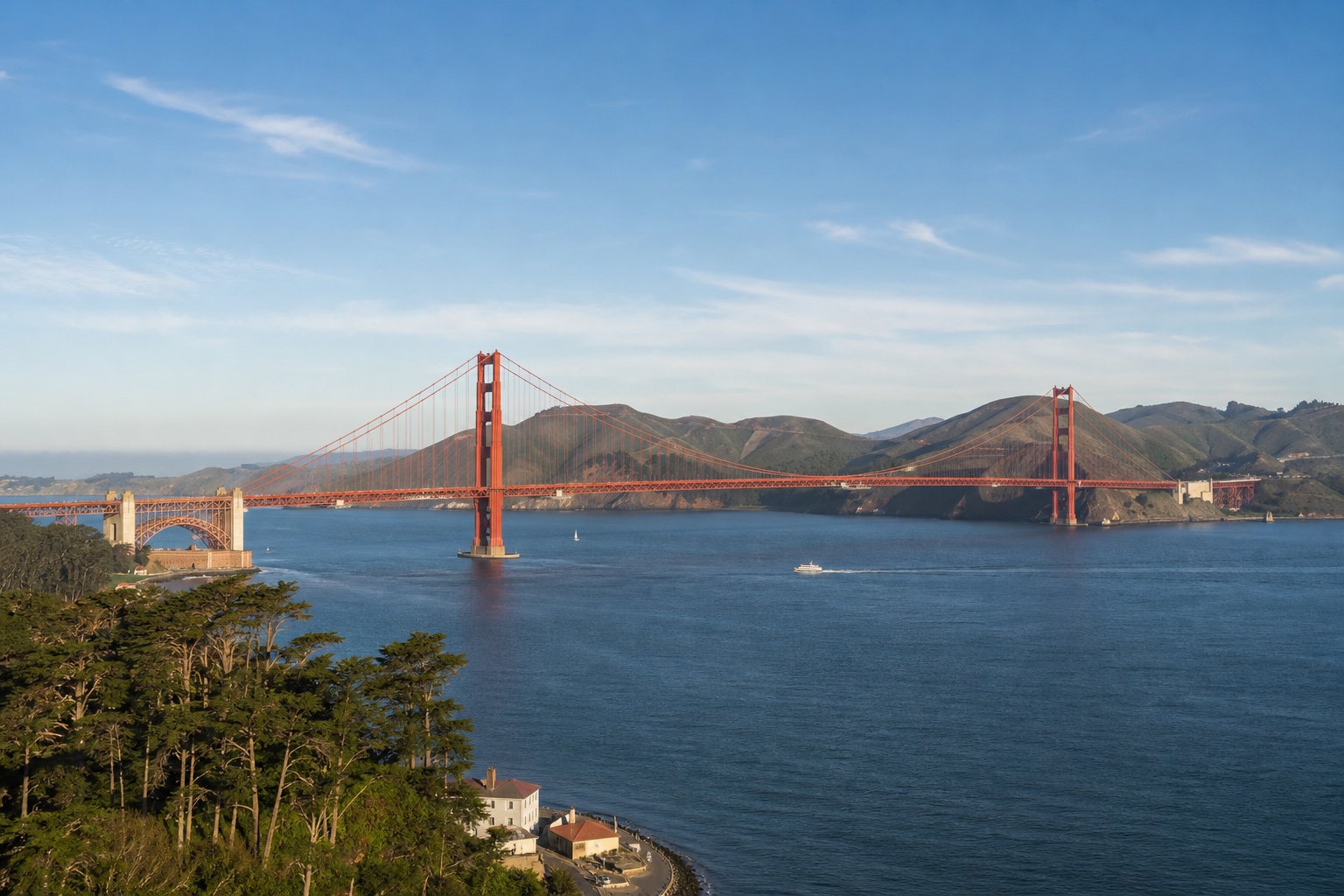 The Golden Gate Bridge spanning blue bay water toward the Marin Headlands