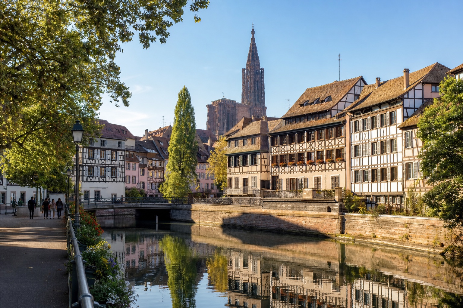 Strasbourg Cathedral rising beyond the canals and half-timbered houses of Petite France in morning light