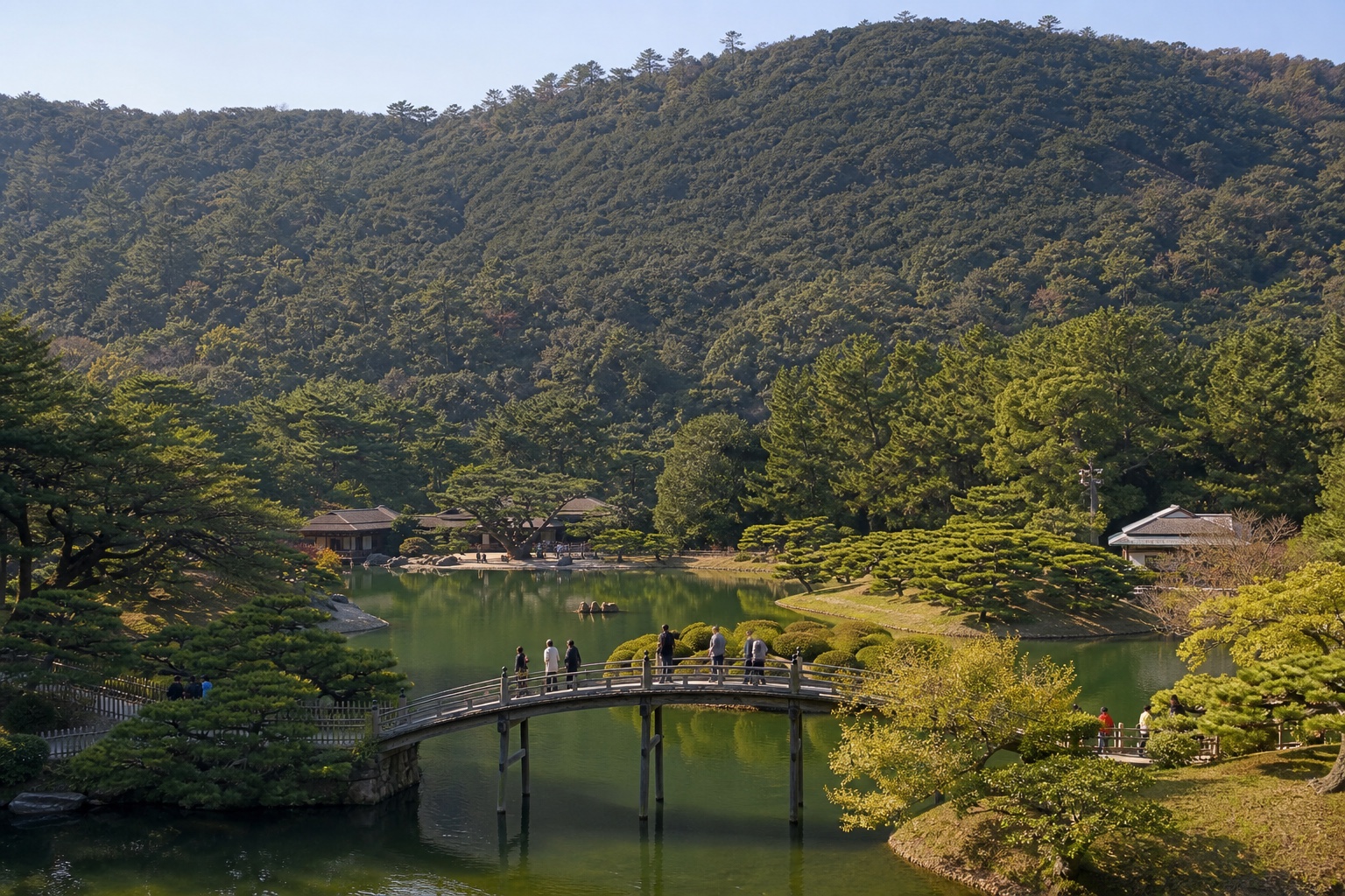 Ritsurin Garden pond, sculpted pines, bridge, visitors, and Mount Shiun in Takamatsu
